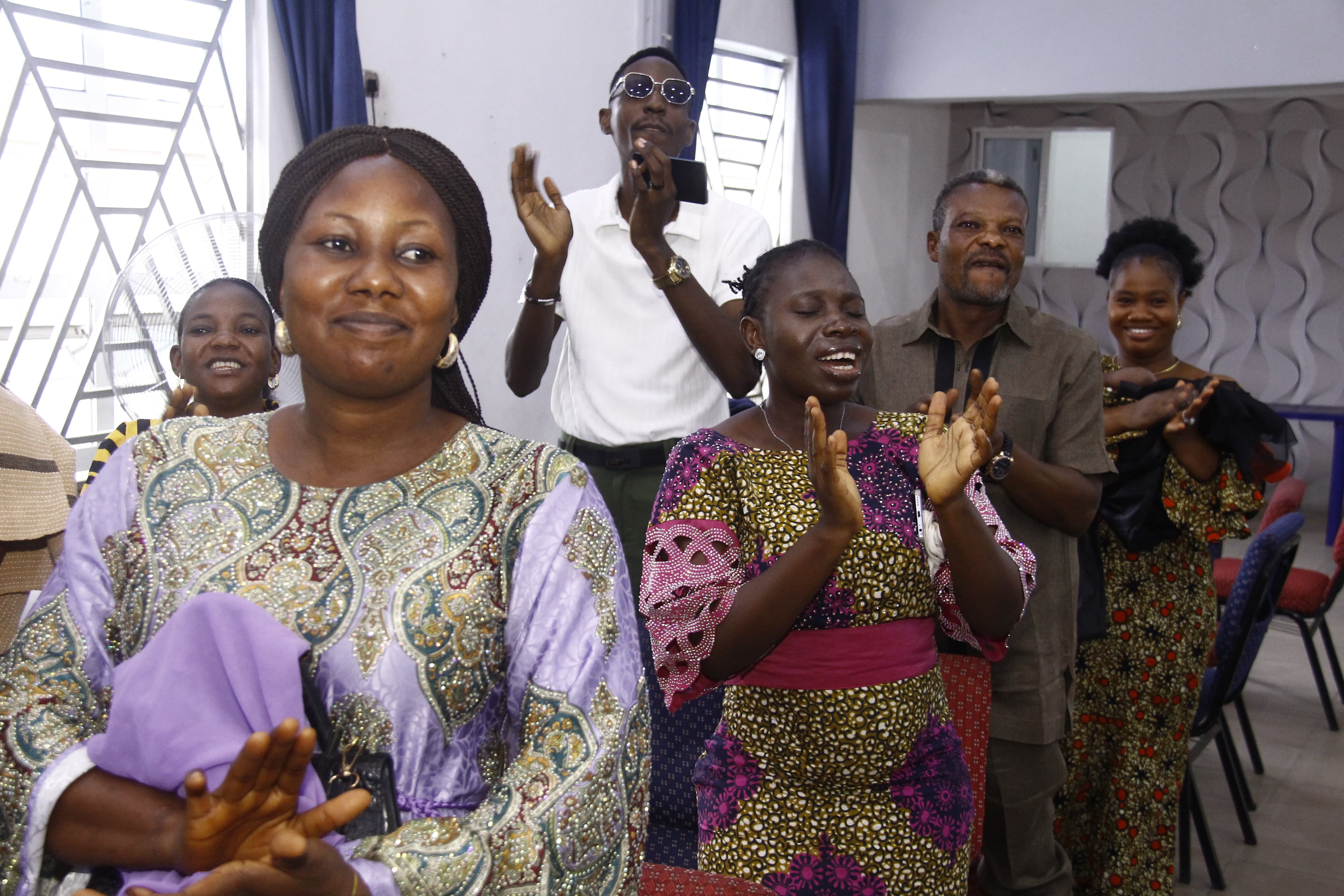 Group clapping and smiling together in colorful outfits