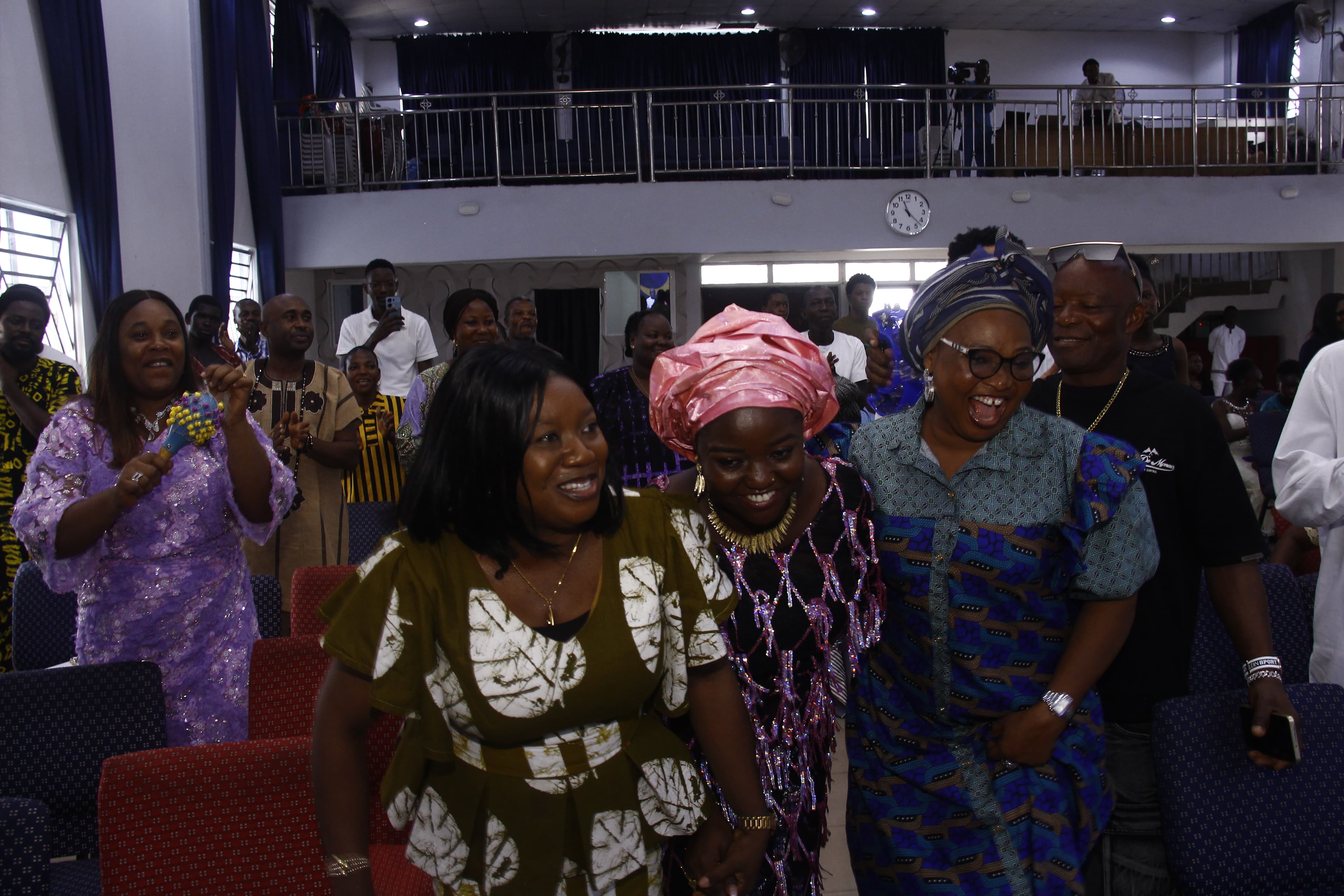 Three women walking and laughing down the aisle