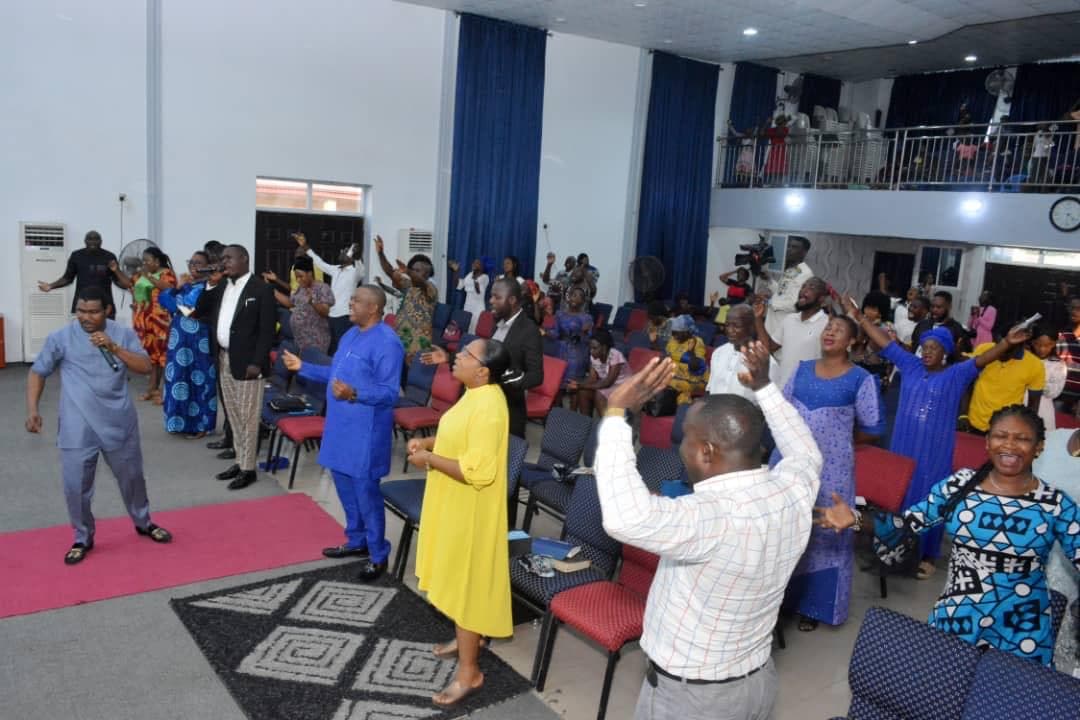 Congregation on their feet in bright colorful attire