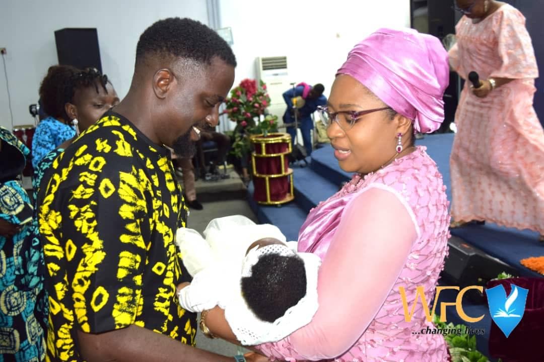 Couple with newborn during baby dedication ceremony