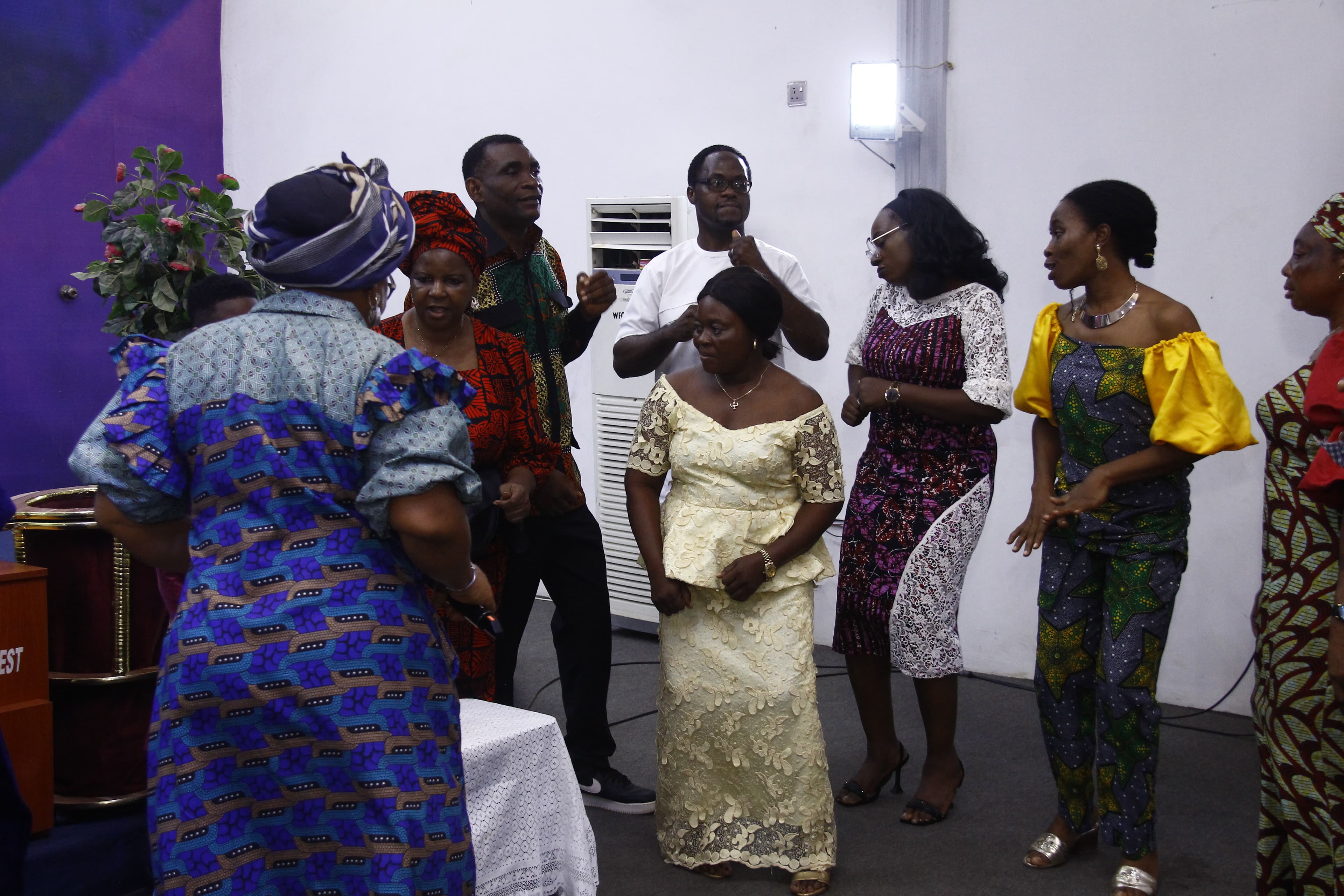 Joyful group fellowshipping at the altar in colorful outfits