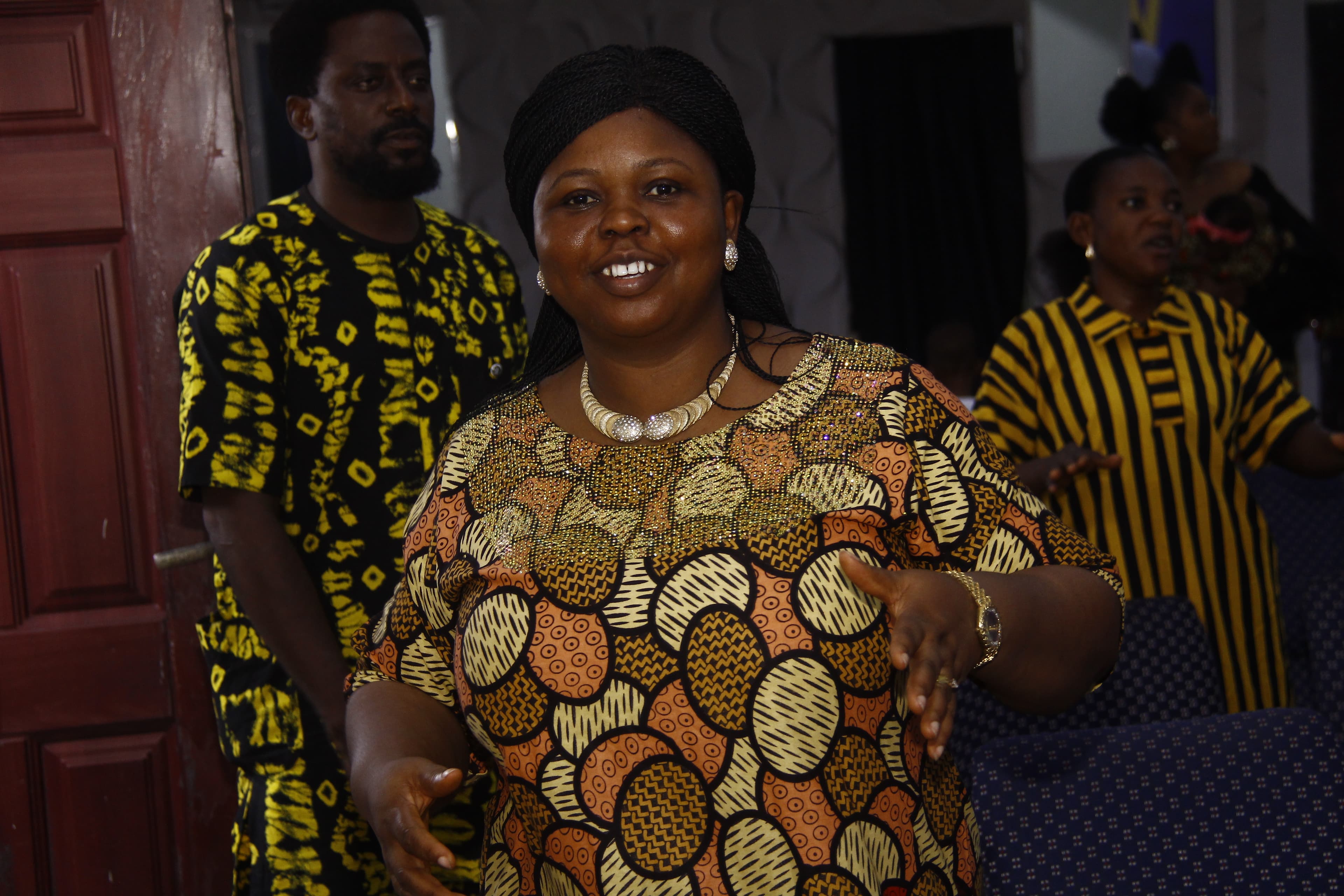 Woman smiling broadly in colorful African print dress