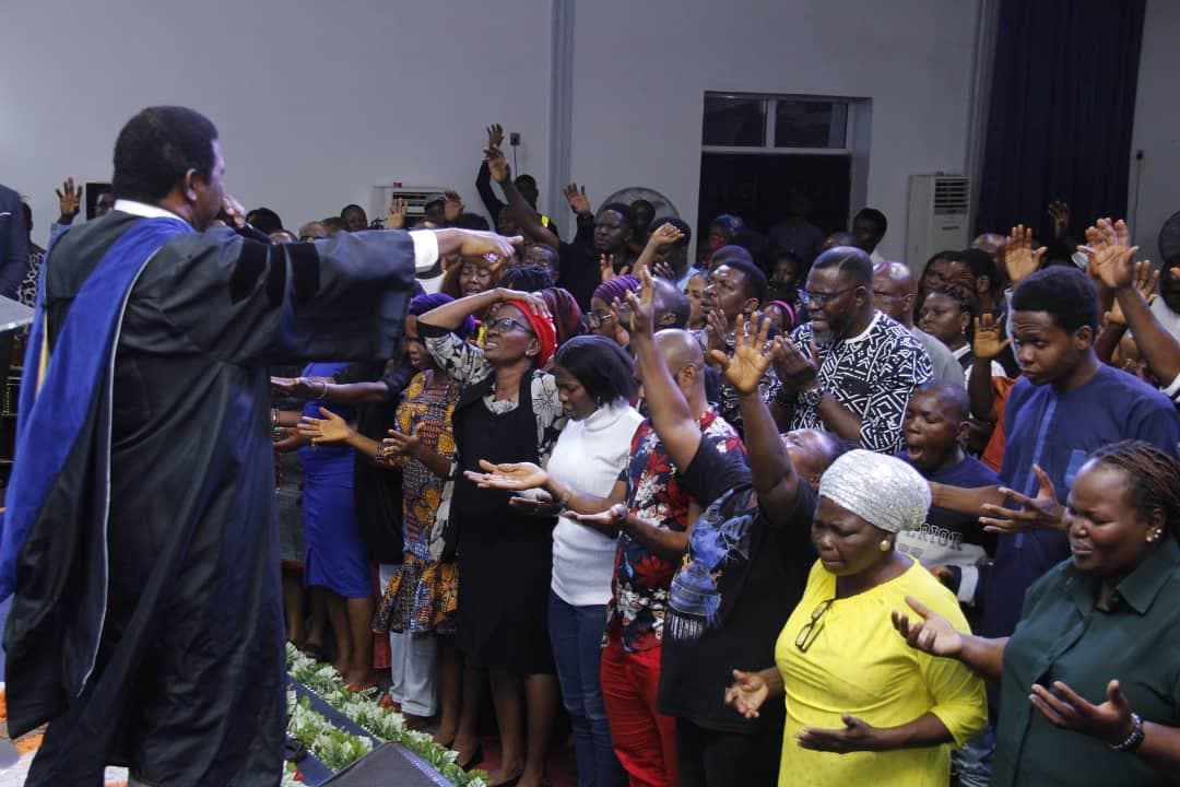 Pastor extending hands over congregation in prayer