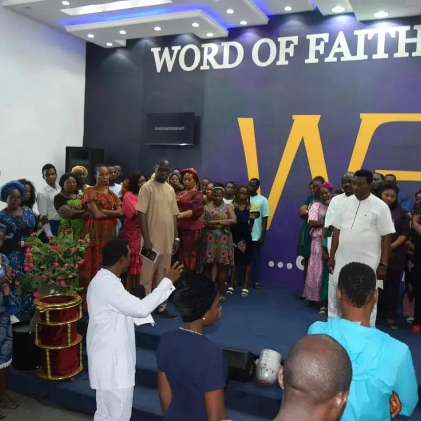 Pastor ministering to woman at the altar with crowd gathered