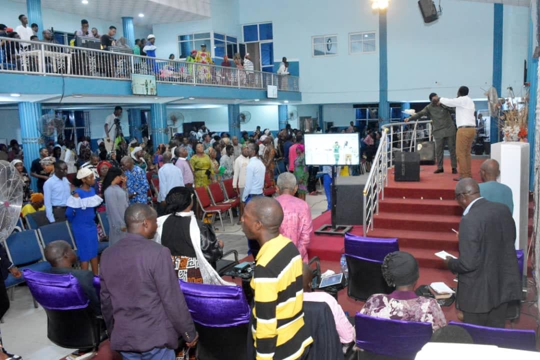 Wide shot of full church with pastor speaking from platform