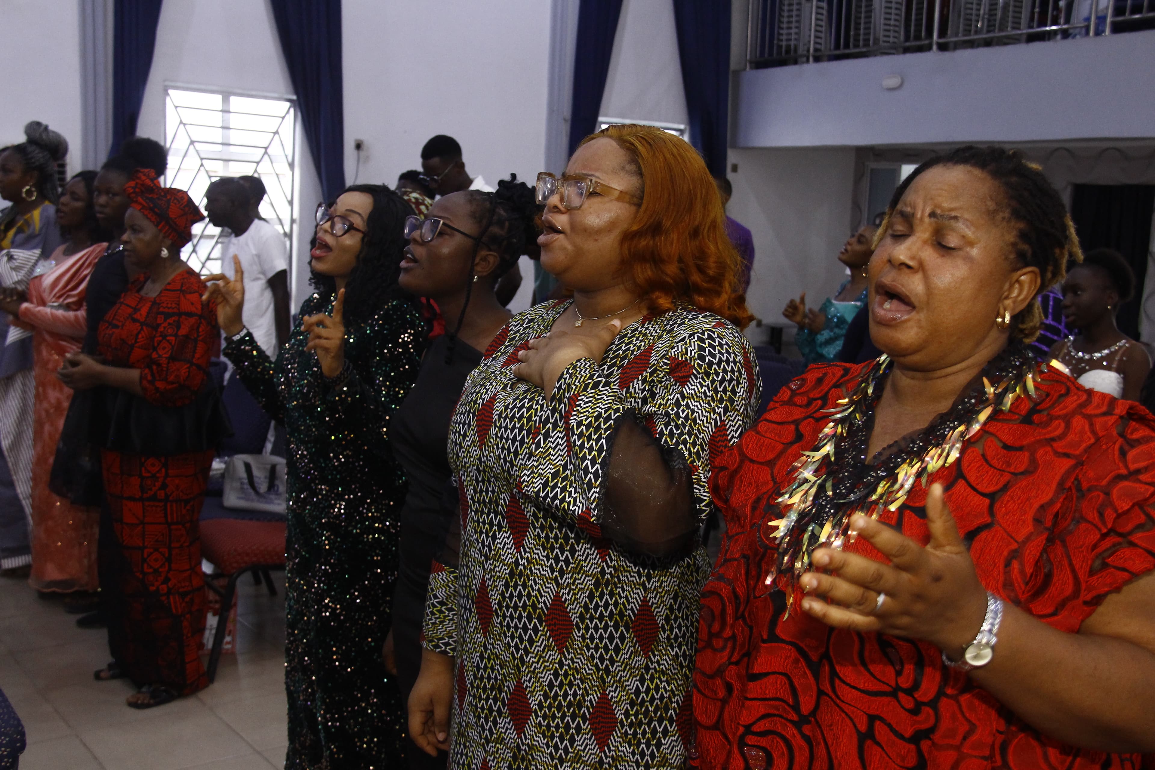 Women standing with eyes closed in deep worship