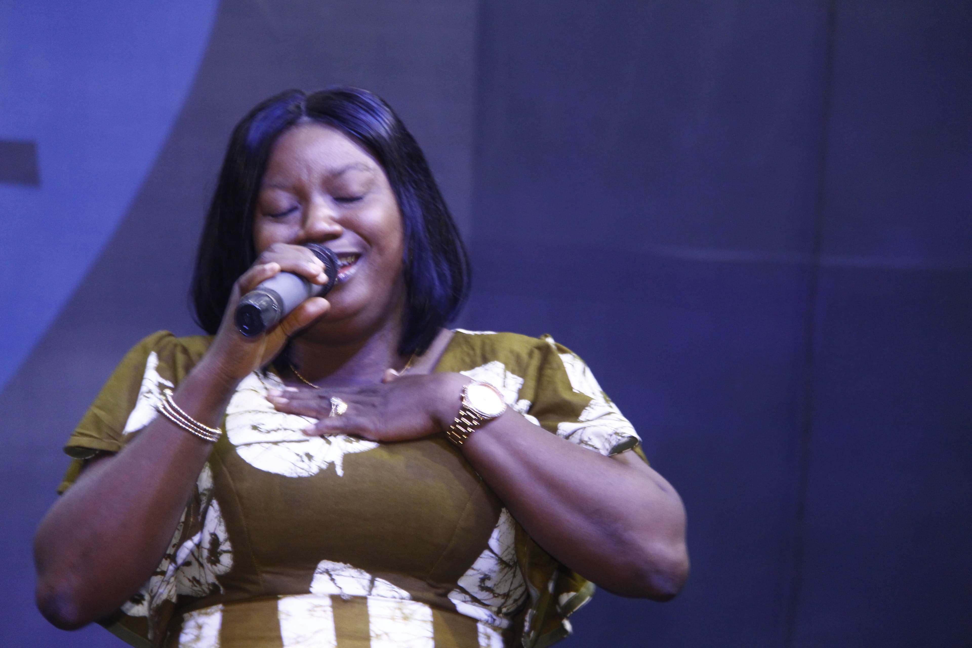 Woman singing with hand on chest in heartfelt worship