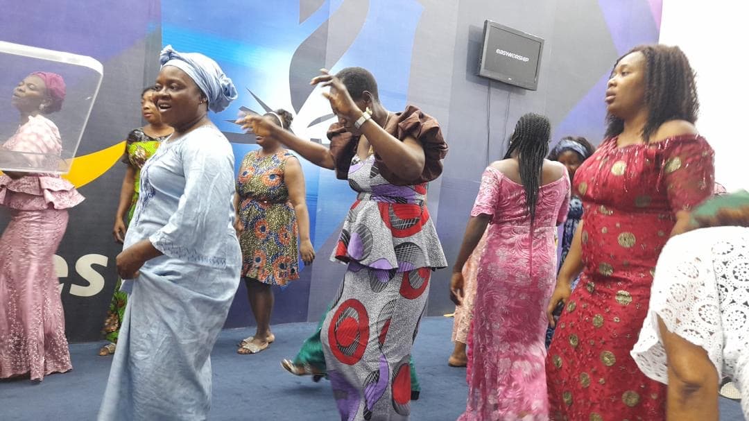 Women at the altar worshipping in colorful African prints